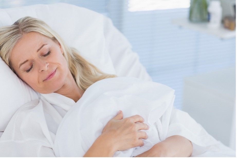 A person lying in a hospital bed